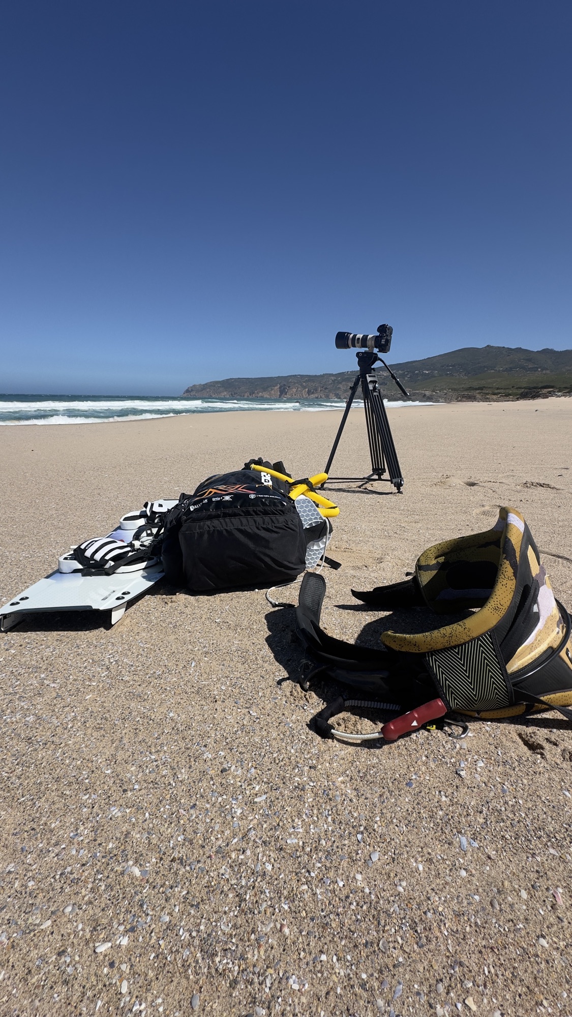 Cámara en trípode grabando deporte de acción en la playa