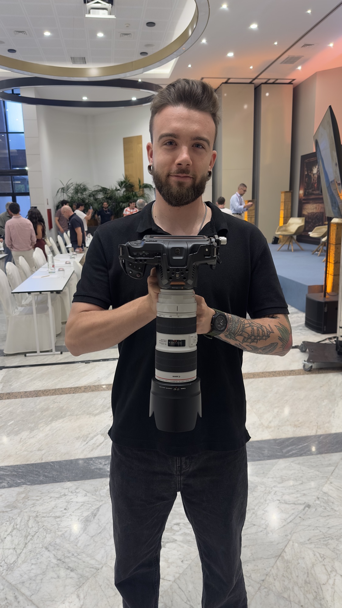 Sujetando cámara con teleobjetivo en un evento corporativo